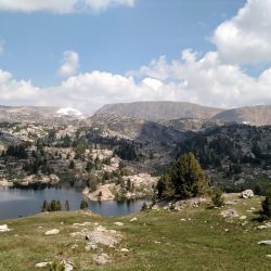 A hiker peers across Beauty Lake in the Beartooth Mountains of Wyoming