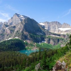 Lake Grinnell below towering Mt. Gould and snow pocketed mountains in Glacier National Park
