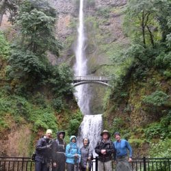 hikers in front of a waterfall
