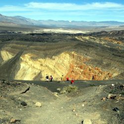 Overlooking the Ubehehe Crater in Death Valley National Park amid the stark desert landscape under a bright blue sky.