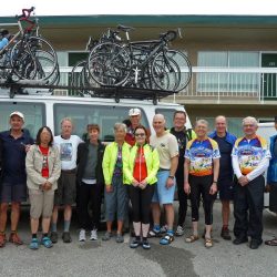 Group of cycling posing in front of bike van