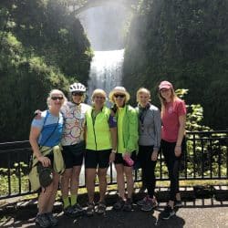 group of women in front of a waterfall
