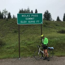 Man on a bike in front of a street sign