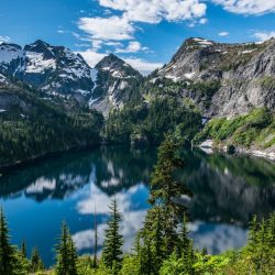 Snowy peaks of the Cascade Range reflect in the calm waters of Doubtful Lake in North Cascades National Park