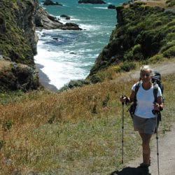 hiker posing in front of a cliff on the beach