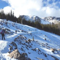 Snowshoers cross a talus slope on the side of Flattop Mountain towards Fern Canyon in Rocky Mountain National Park