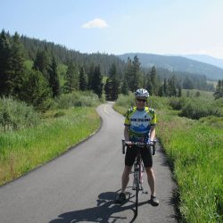 A cyclist taking a break on the Vail Pass Bike Path on a sunny day in Colorado