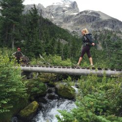 hiker walking over a bridge