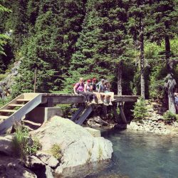 Hikers on a bridge over a river