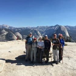 Hikers pose on top of Sentinel Dome, overlooking the Yosemite Valley and Half Dome in California