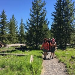 Two hikers pose on a trail in Yellowstone National Park
